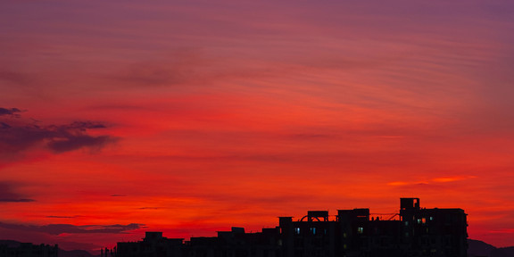 Das Bild zeigt die Morgendämmerung über einer Stadt.