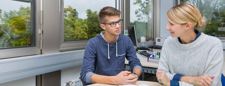 Zwei Personen sitzen an einem Tisch