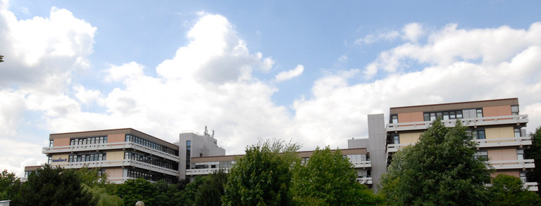 Emil-Figge-Straße 50 mit Wolken und grünen Bäumen im Hintergrund 